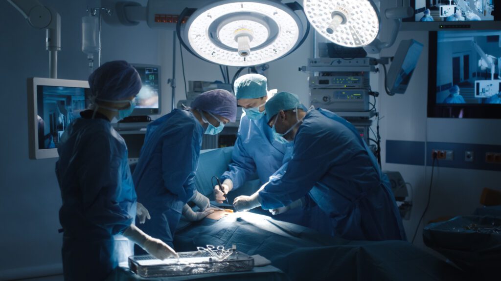 Surgical team performing operation under bright lights