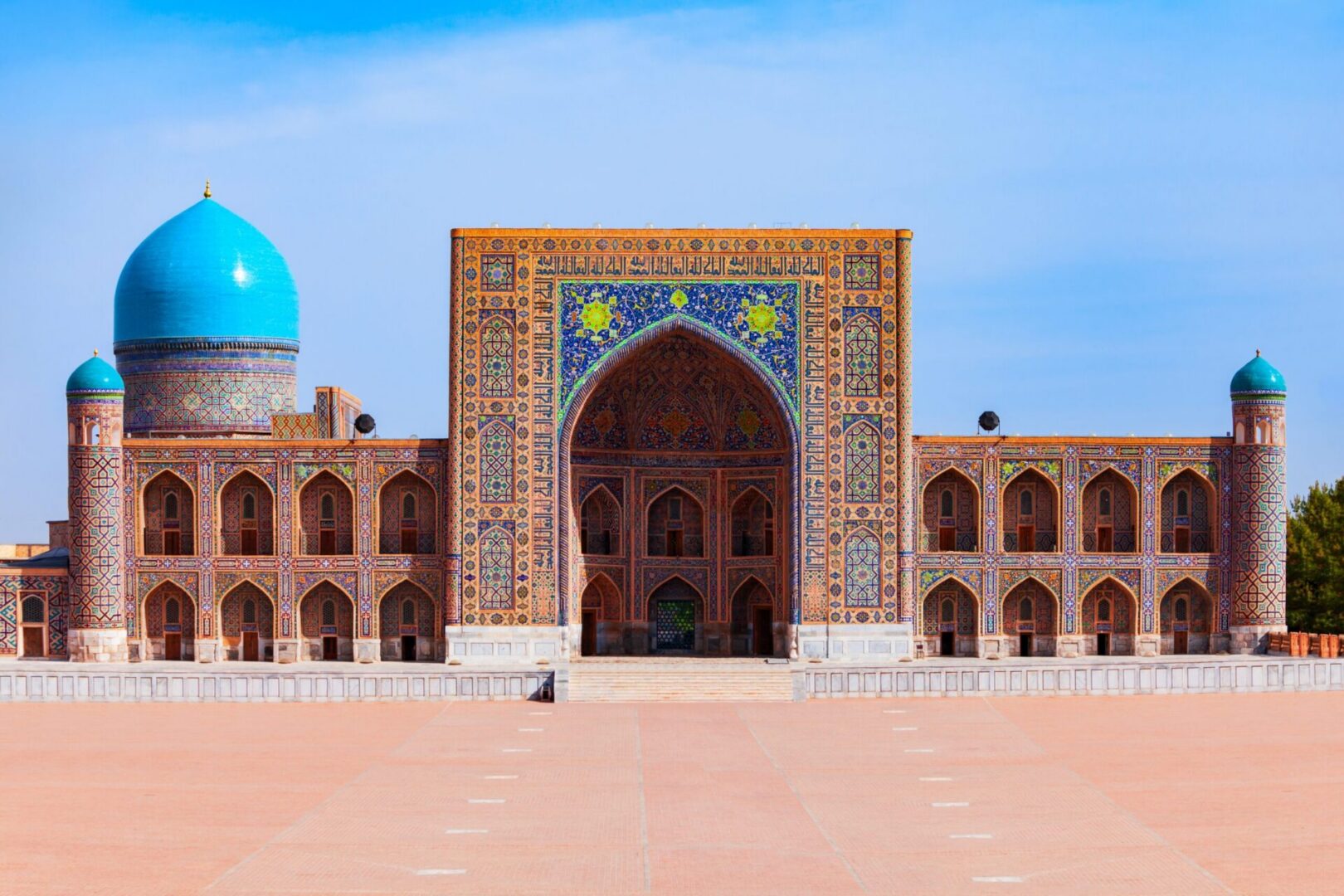 Colorful tiled mosque façade with blue domes